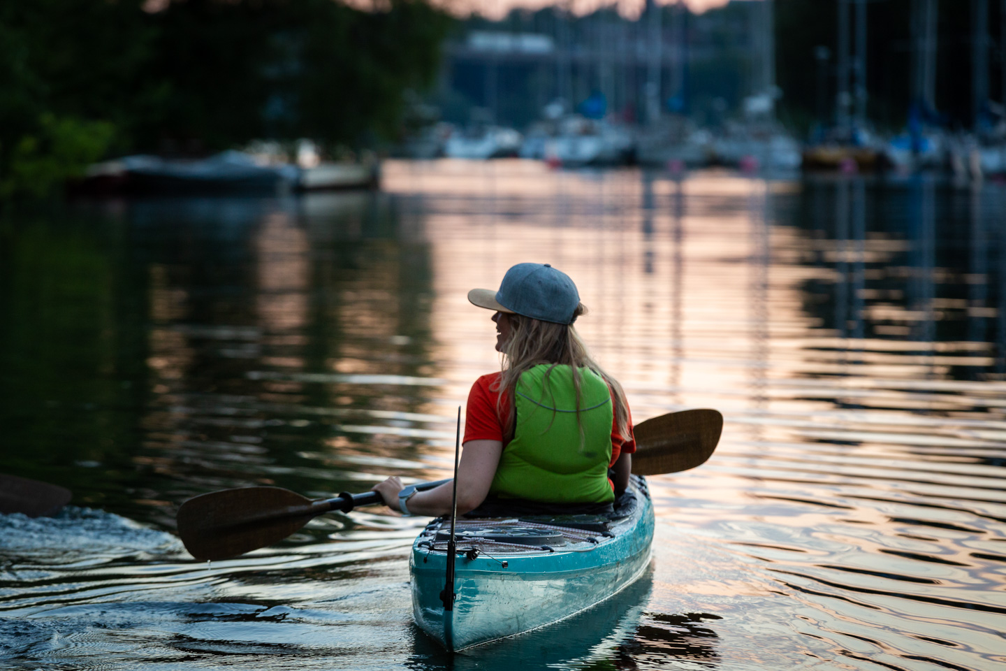 Person paddlar kajak runt långholmen på en självguidad tur från Eden Kajak & SUP. Det är solnedgång och kajaken glider fram genom pålsundet.